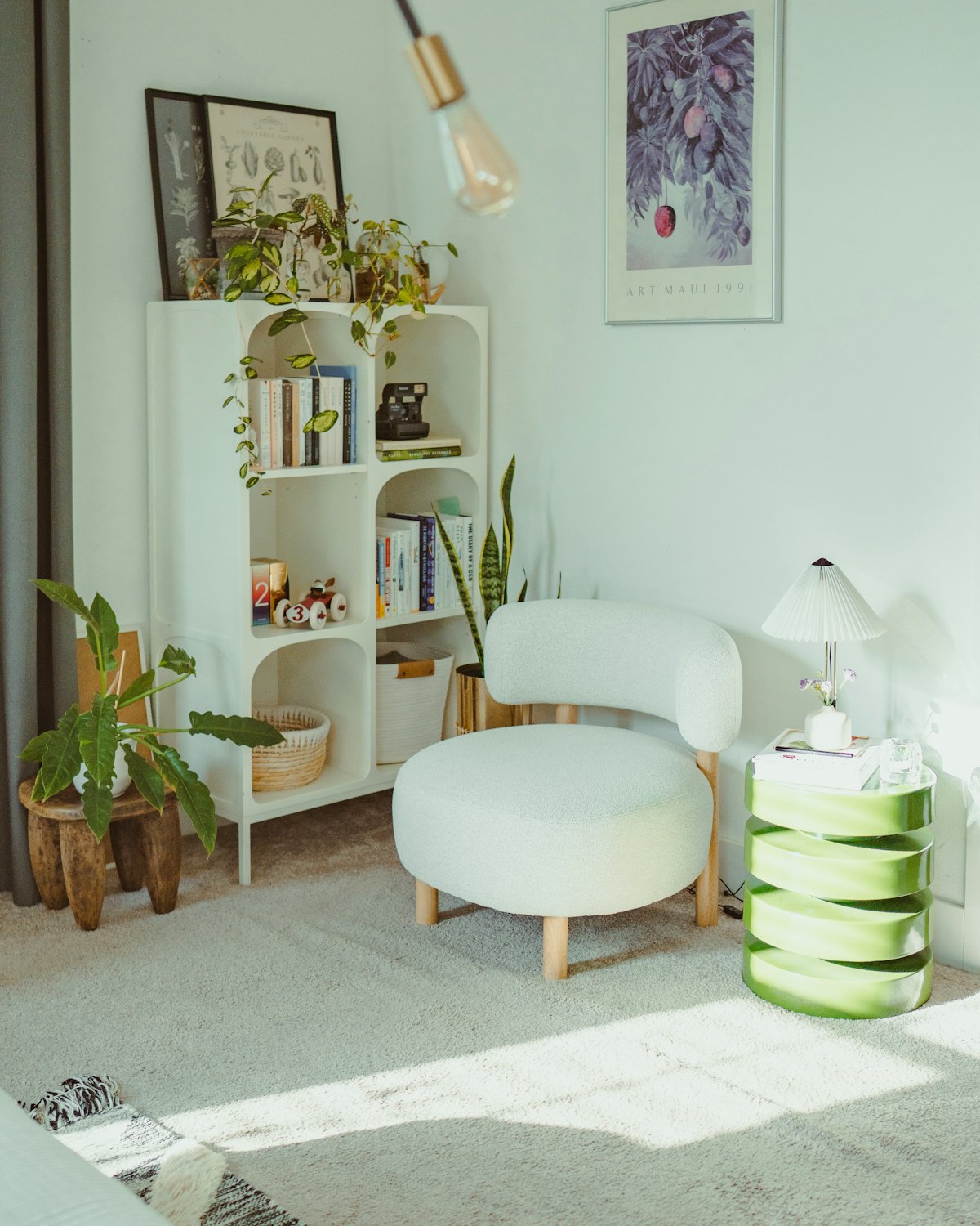A cozy corner with a bookshelf, armchair, and potted plants, no people