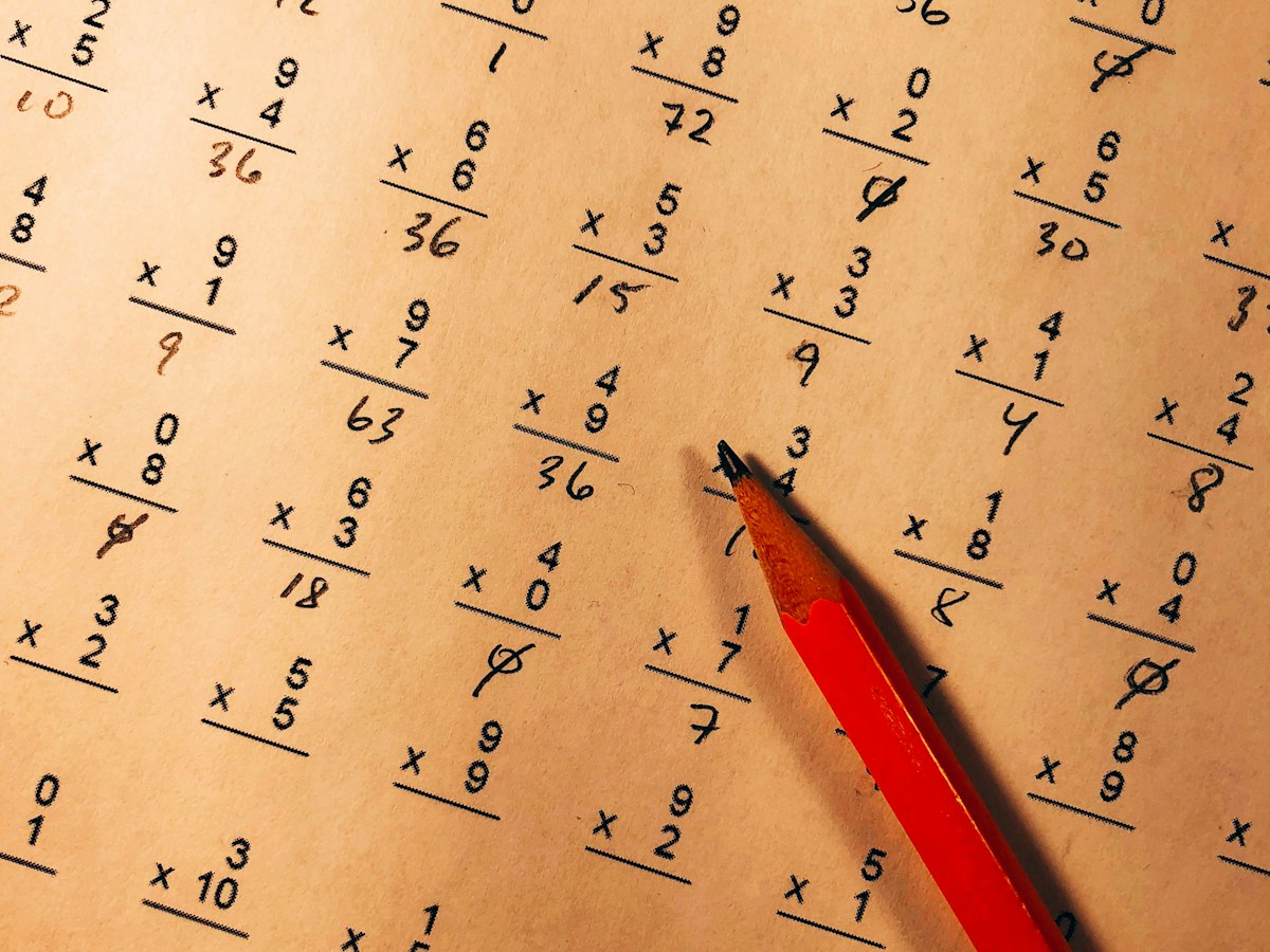 A graded multiplication worksheet marked with a red pencil
